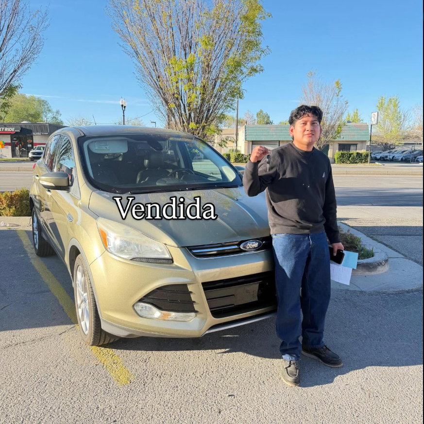 A Los Oviedo customer holding up the keys next to the SUV he traded up to, marked Vendida